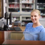 Nurse practitioner in a non-clinical role at desk with computer