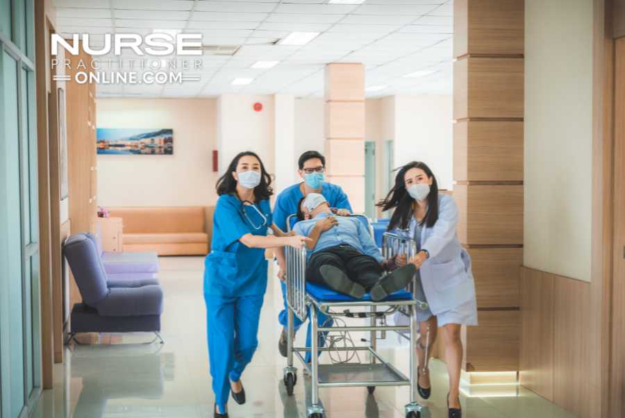 A team of medical professionals, including an emergency nurse practitioner, wheel a patient lying on a gurney down a hospital hallway.