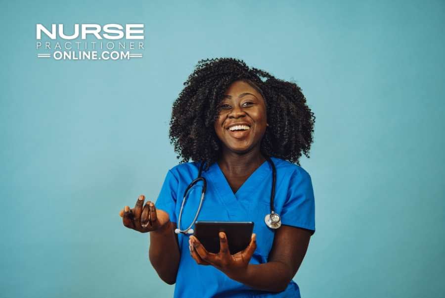 A nurse practitioner smiles while holding a small tablet.