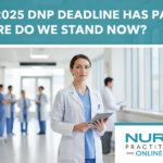 DNP-level NP standing in the hallway of a hospital holding a clipboard